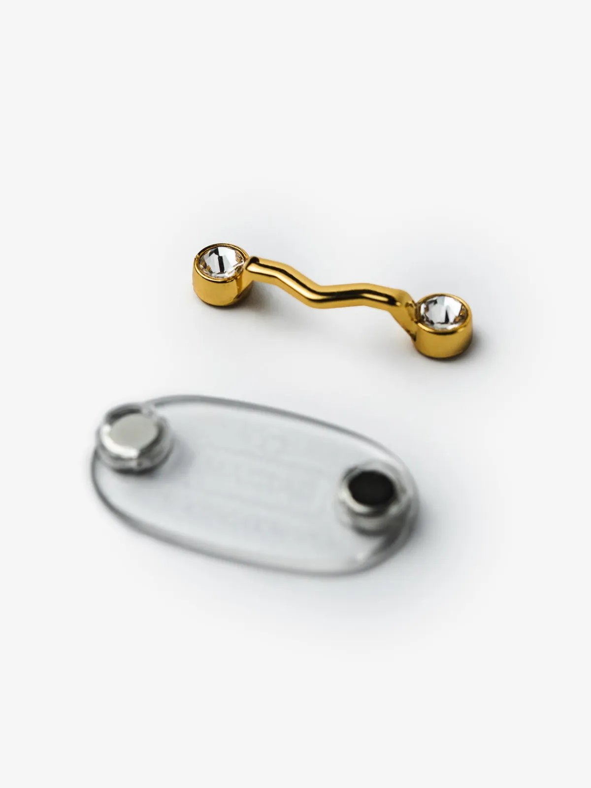 Peça frontal e base do MagTag Lux Ouro, separadas, em ângulo